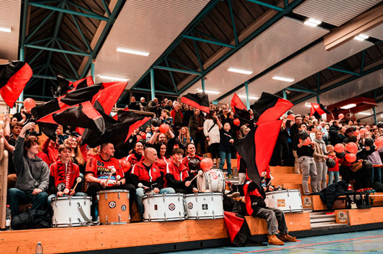 Bei den Heimspielen des MTV Braunschweig in der Sporthalle Alte Waage ist Block A fest in der Hand des leidenschaftlichen Fanklubs Harzblock 383 aus Schladen. Foto: Lando Reinberger